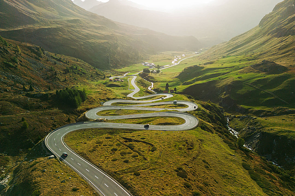 Serpentinenstraße durch Berglandschaft.