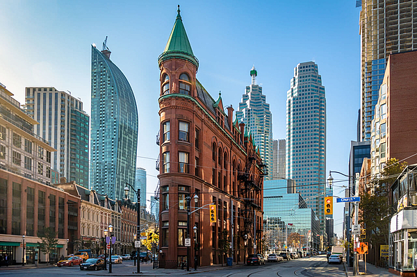 Historisches Backsteinhaus vor modernen Hochhäusern in Toronto.