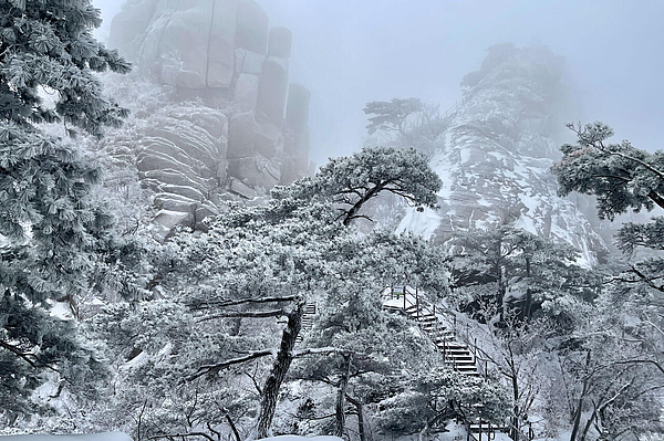 Verschneiter Bergpfad mit Stufen.