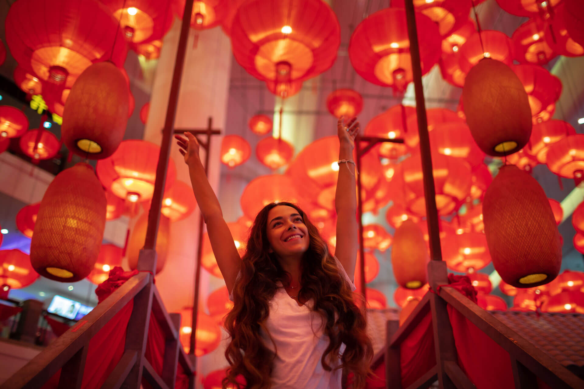 Teilnehmerin einer Sprachreise in Peking beim Laternenfest in festlich belehnter Straße