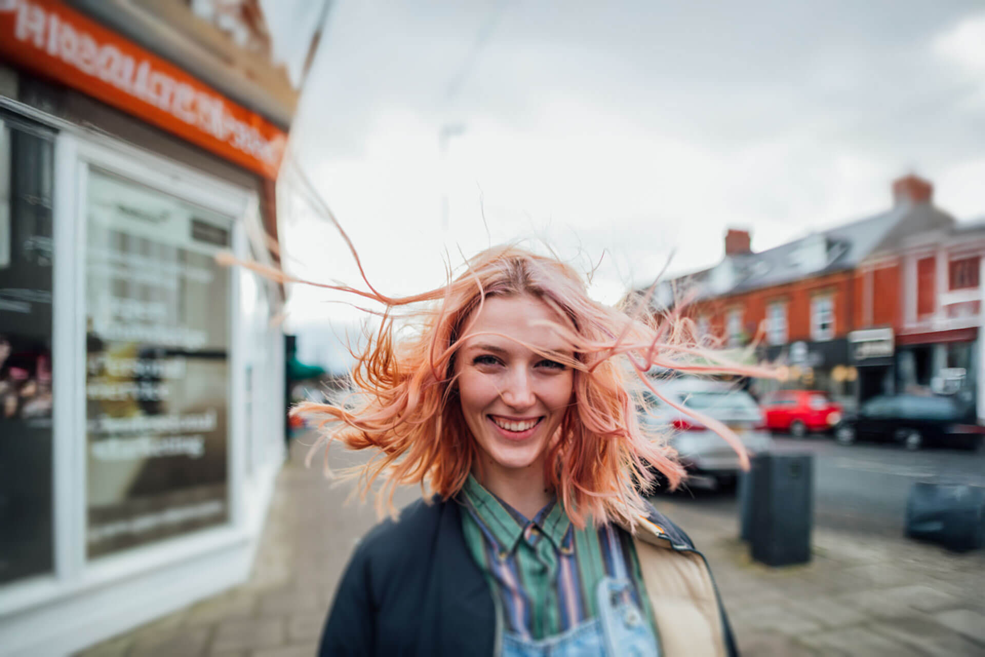 Teilnehmerin einer Englisch Sprachreise lacht vor der Sprachschule und trainiert Aussprache im Sprachkurs