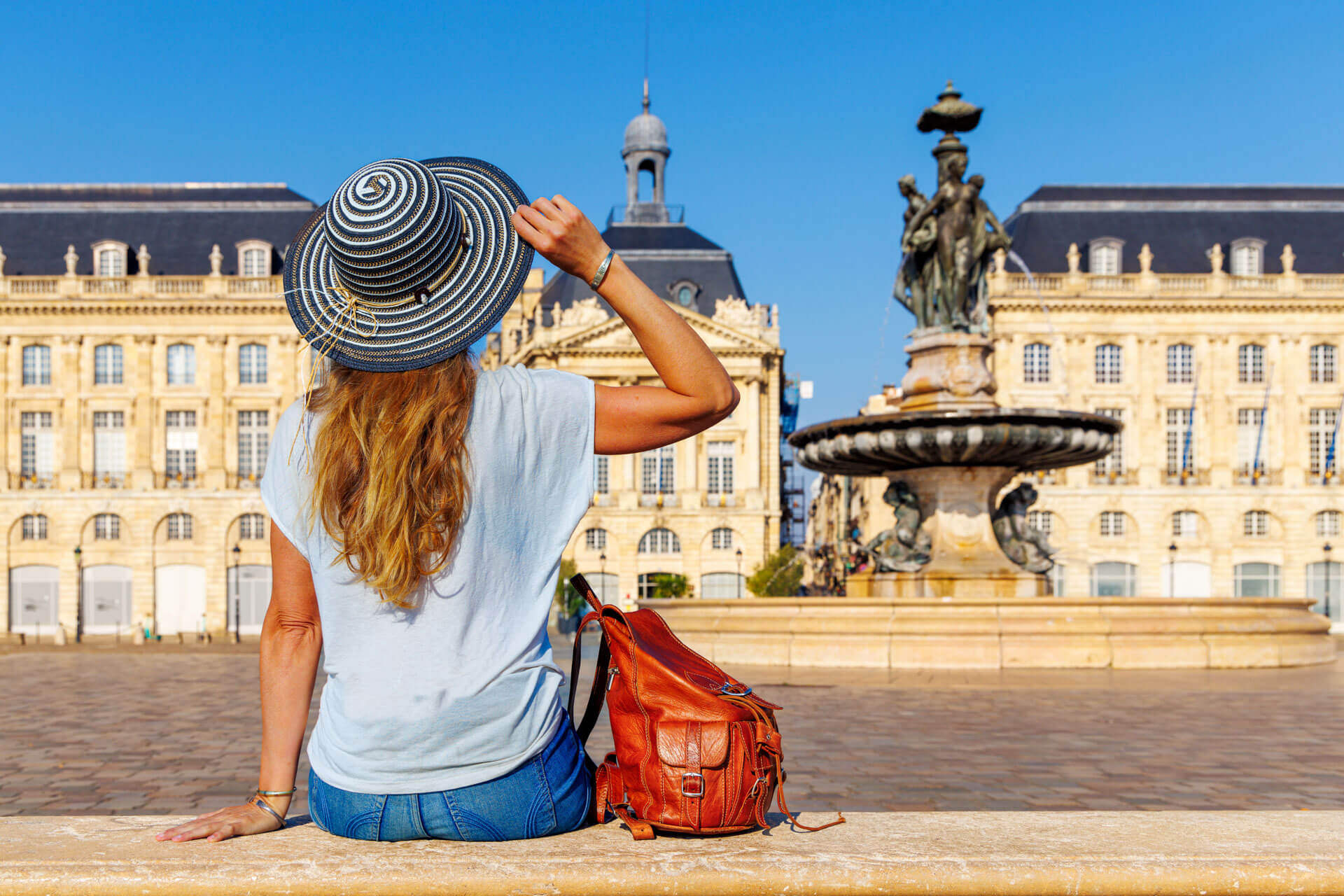 Frau mit Sonnenhut vor der Place de la Bourse in Bordeaux