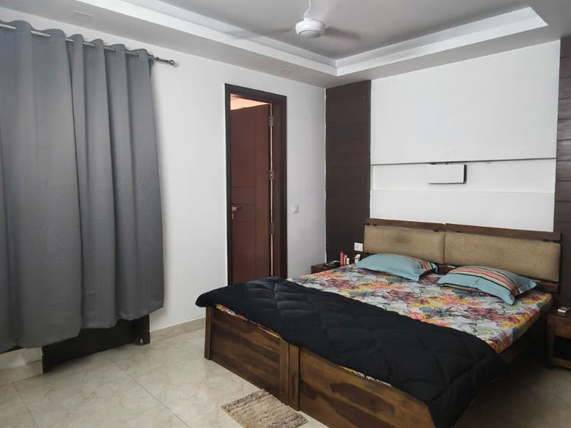 Geräumiges Schlafzimmer im Apartment in Neu-Delhi mit Doppelbett.