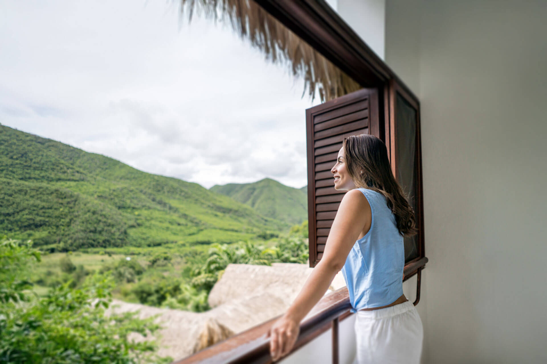 Teilnehmerin einer Sprachreise in Kolumbien genießt den Blick auf die grüne Hügellandschaft von ihrer Unterkunft aus