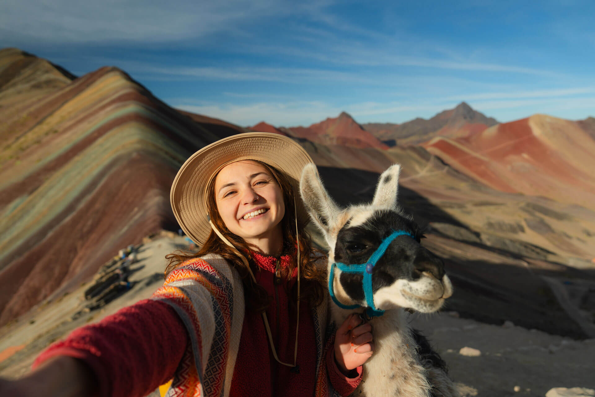 Teilnehmerin einer Sprachreise in Peru mit Lama am Rainbow Mountain nahe Cusco