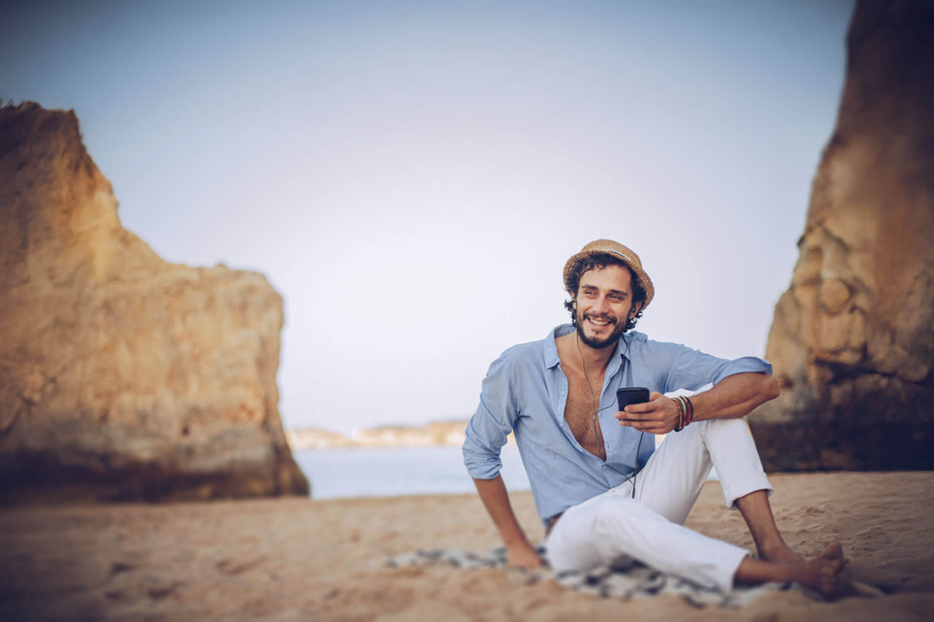 ann sitzt entspannt am Strand der Algarve bei Faro und genießt den sonnigen Tag