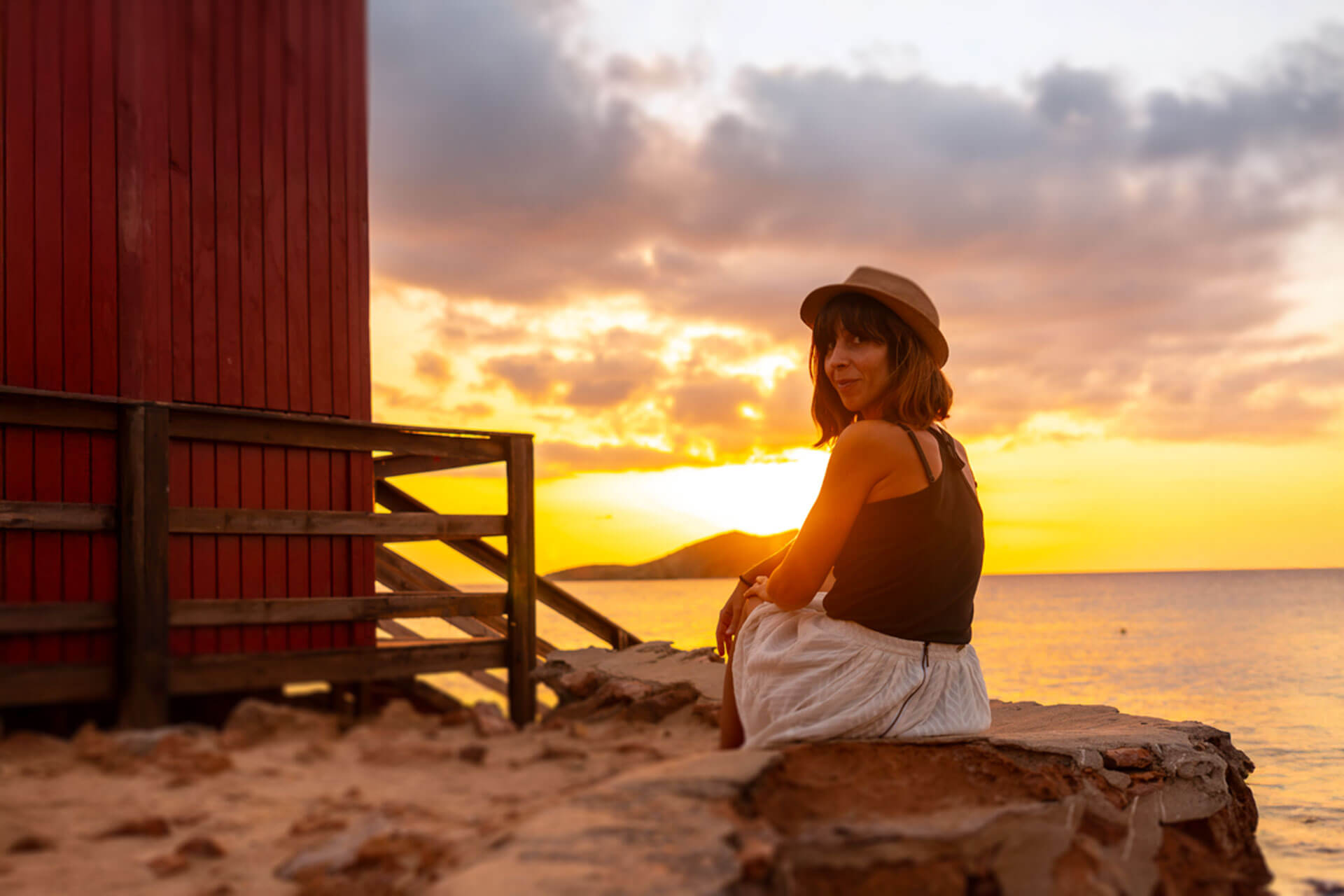 Hörverstehen und Konversation üben am Strand bei Sonnenuntergang auf Ibiza.