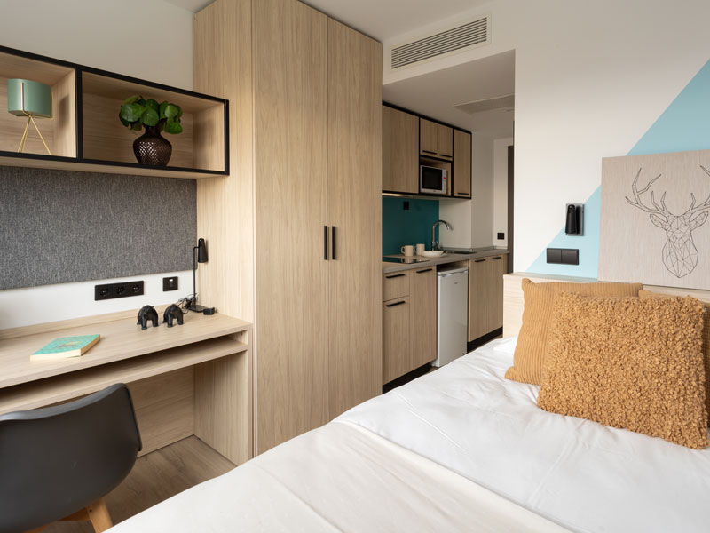 Modern ausgestattetes Einzelzimmer der Residenz in Salamanca mit Bett, Schreibtisch und Küchenzeile für Sprachschüler