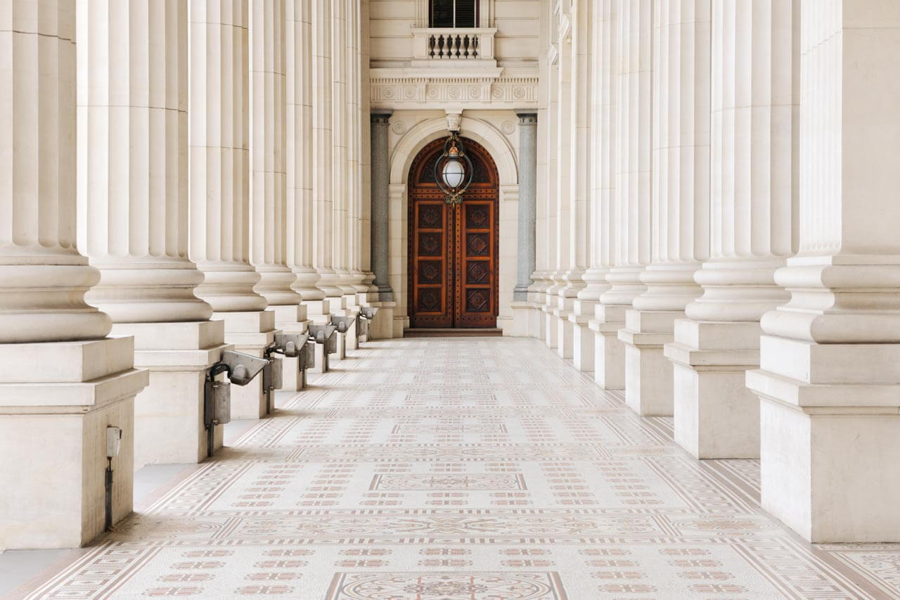 Säulengang mit großer Holztür, Schreibtraining im Unterricht vor Ort.
