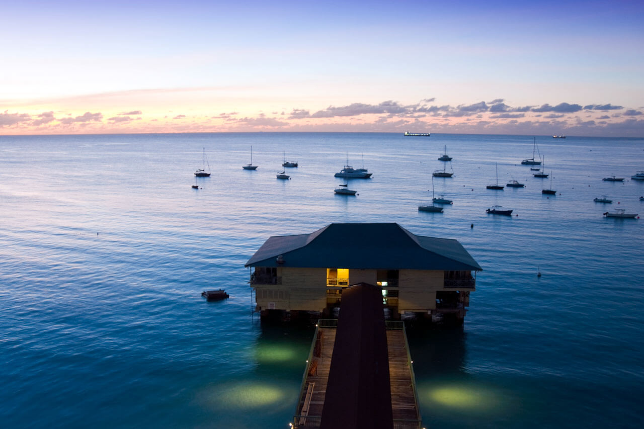 Pier über ruhiger Bucht bei Sonnenuntergang, Sprachkurs am Meer, Grammatik trainieren beim Austausch vor Ort.