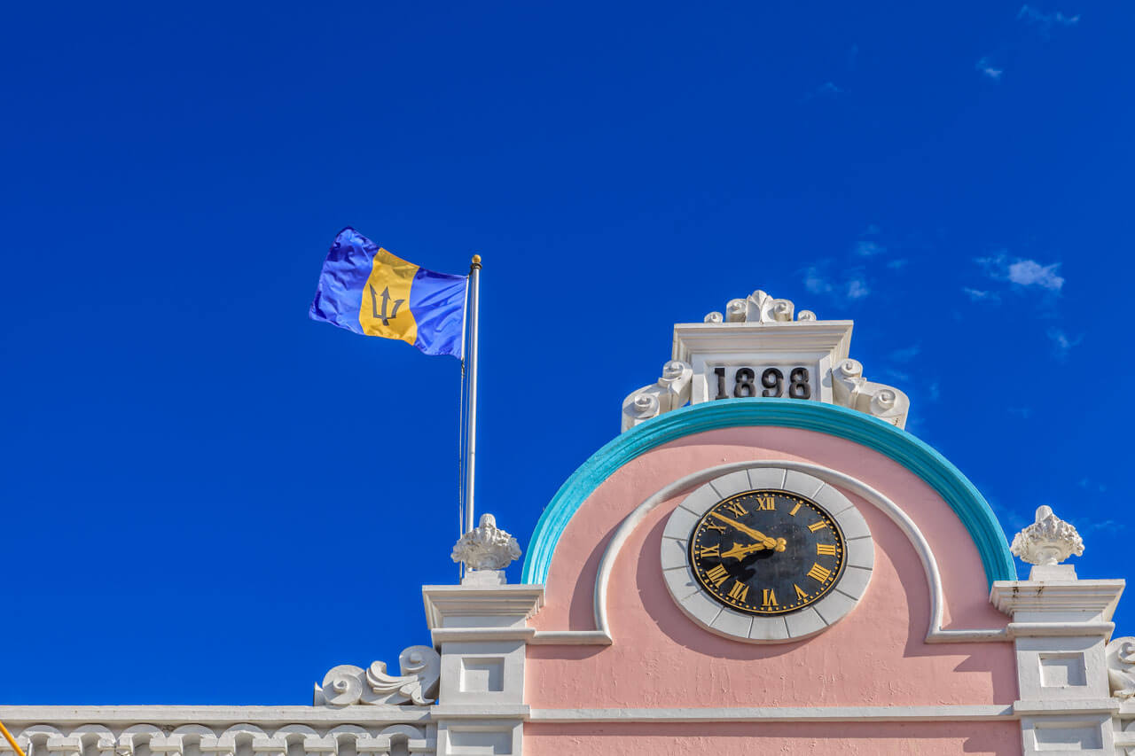 Flagge mit Dreizack über Uhrturm in Bridgetown, Vokabeln üben im Stadtspaziergang.