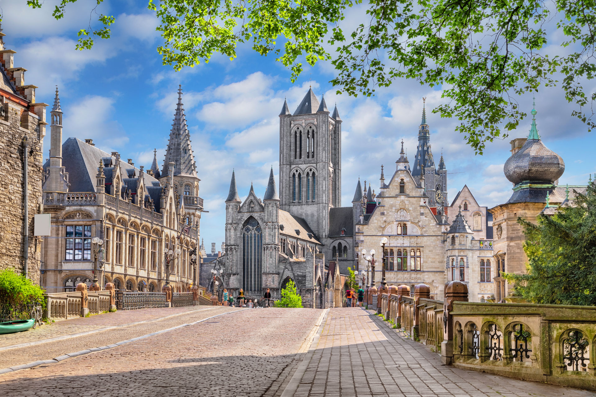 St.-Michaels-Brücke in Gent mit Blick auf St.-Nikolaus-Kirche, Belfried und historische Giebelhäuser bei blauem Himmel