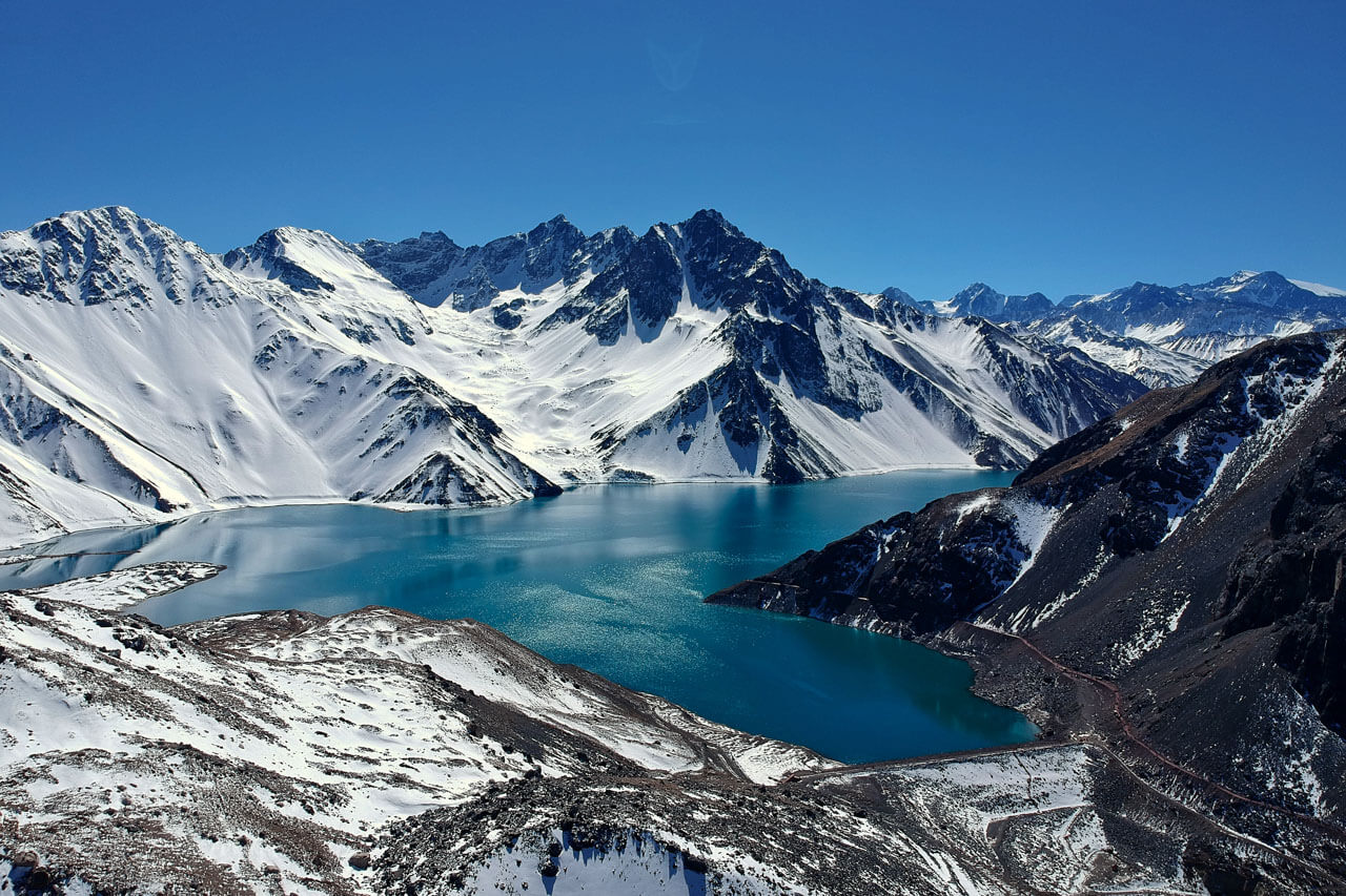 Tiefblauer Stausee im Gebirge bei Santiago de Chile, Ausflug in die Anden während einer Sprachreise