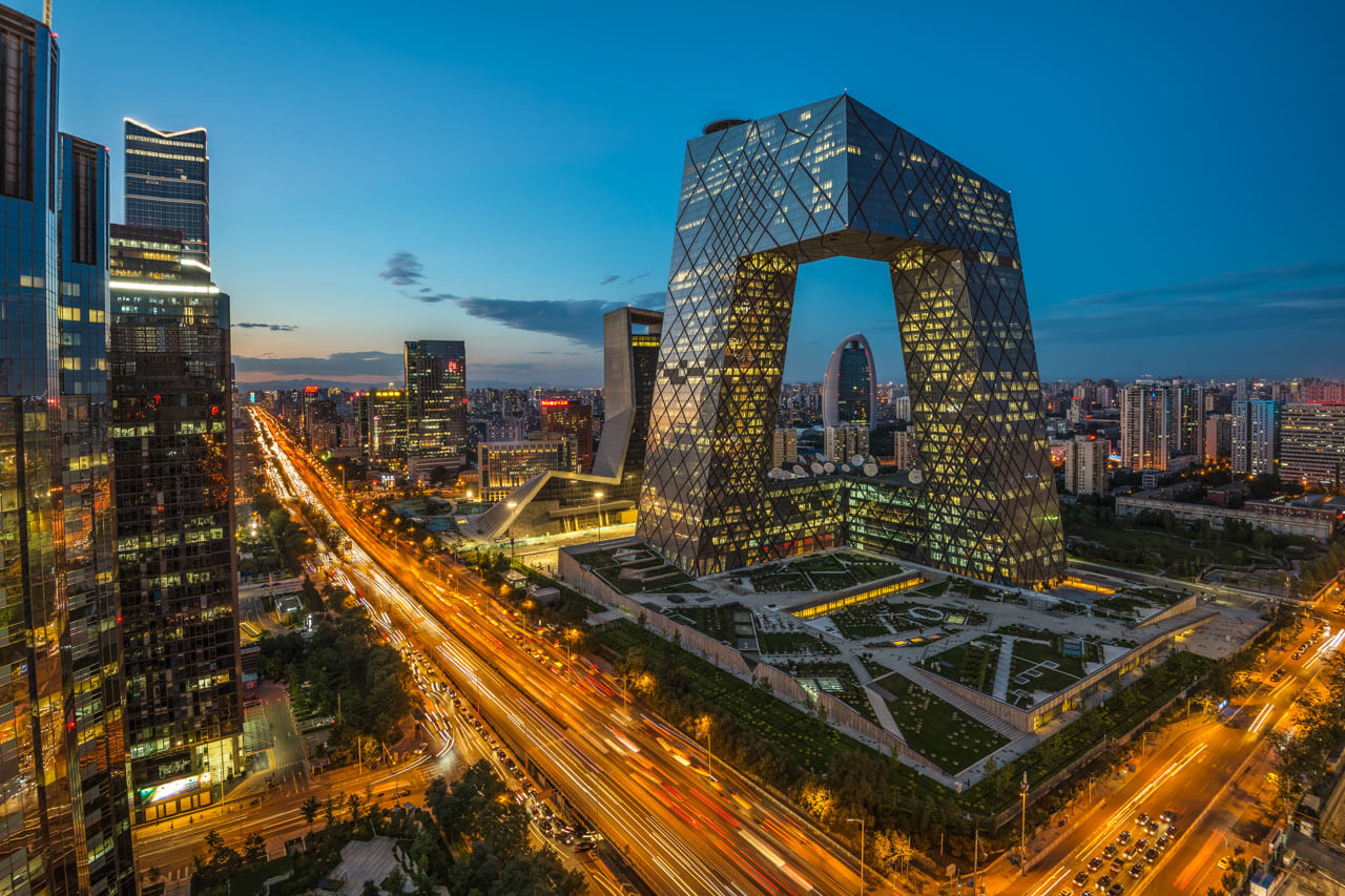 Beijing Skyline mit beleuchtetem CCTV Hauptquartier und Lichtspuren zur Abenddämmerung