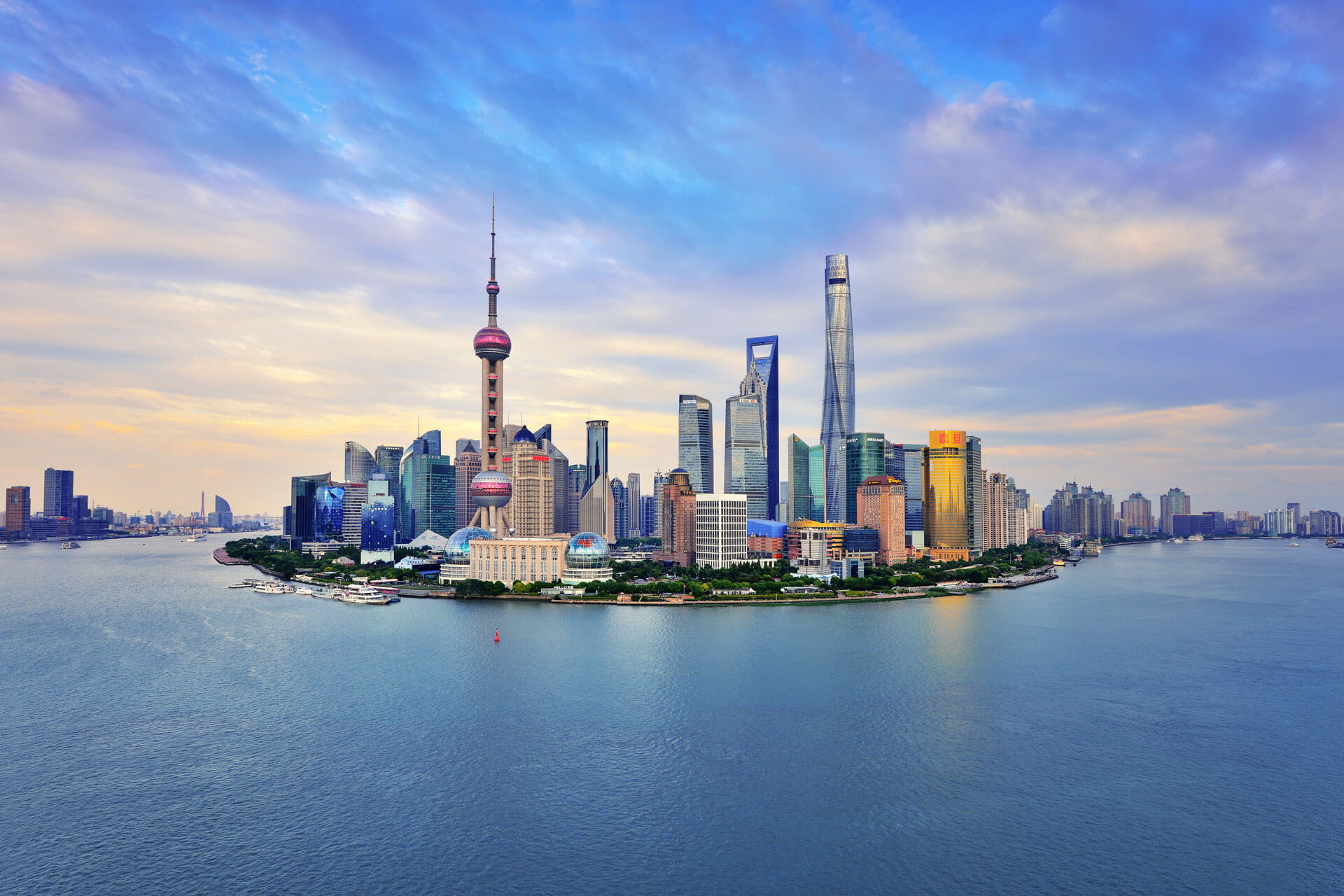 Shanghai Skyline mit Oriental Pearl Tower und Pudong am Huangpu bei blauem Himmel