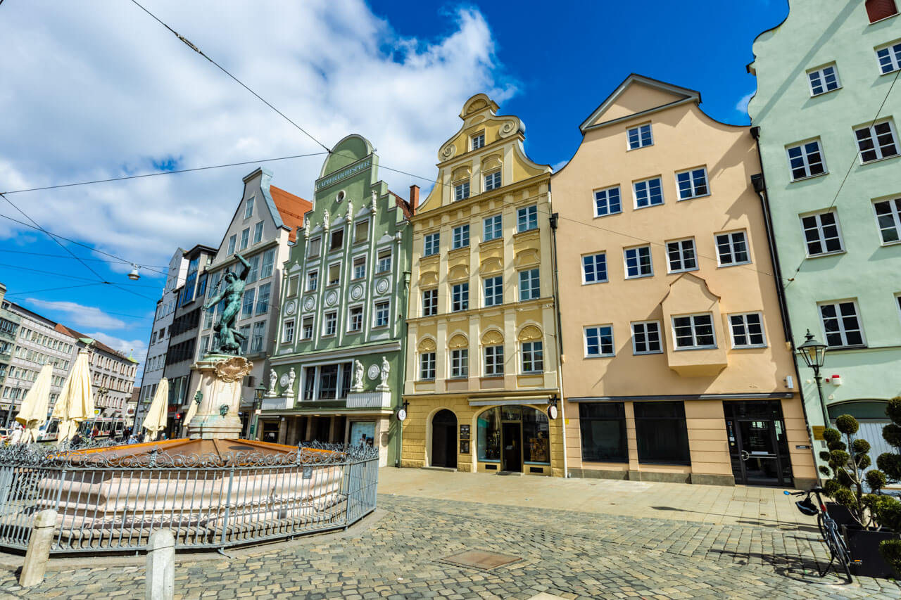Historische Fassaden am Platz mit Brunnen, Adjektive und Beschreiben im Deutschkurs üben.