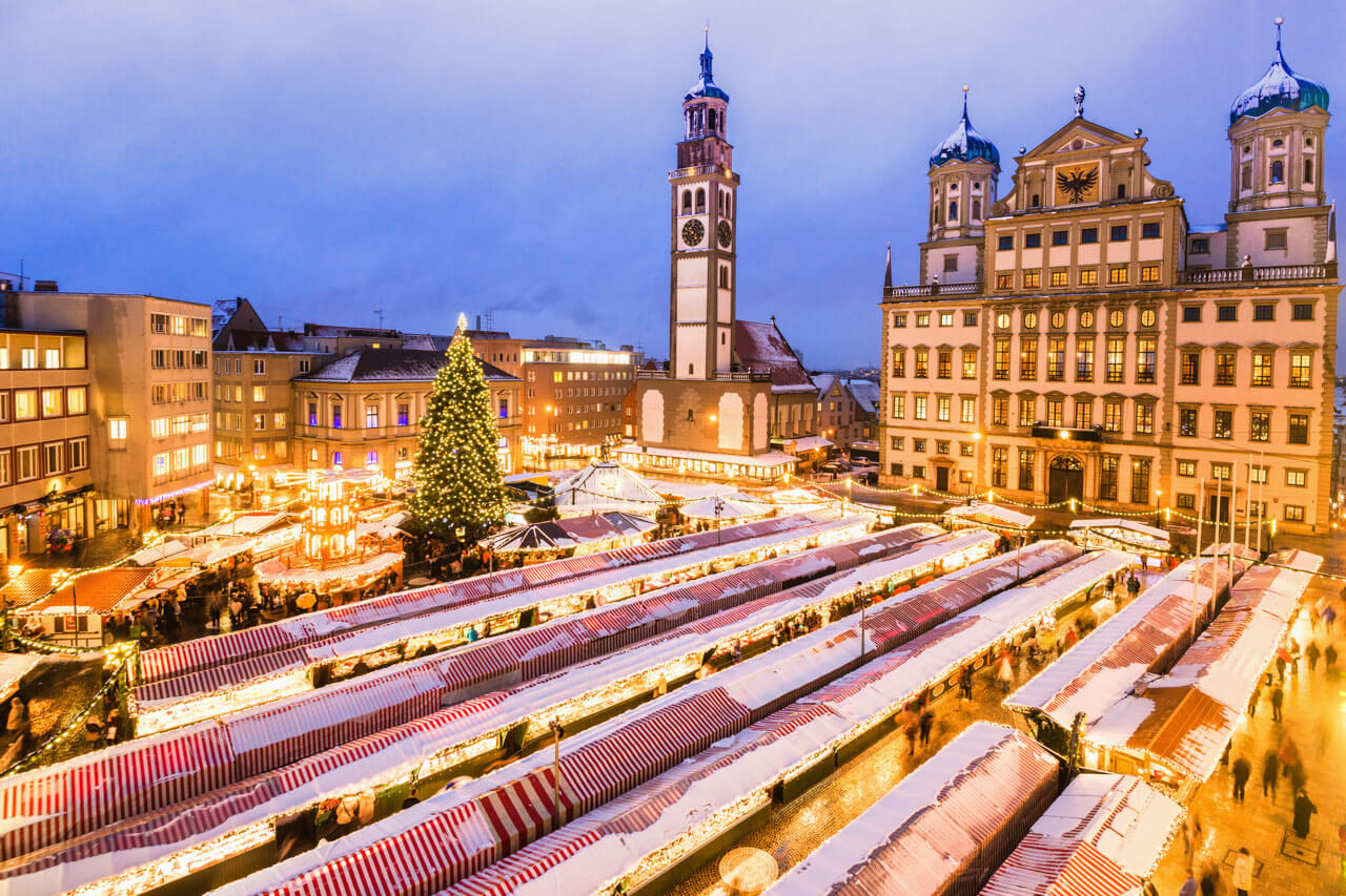 Weihnachtsmarkt mit Lichtern und Rathaus, Sprachreise Augsburg und Deutsch lernen im Winter.