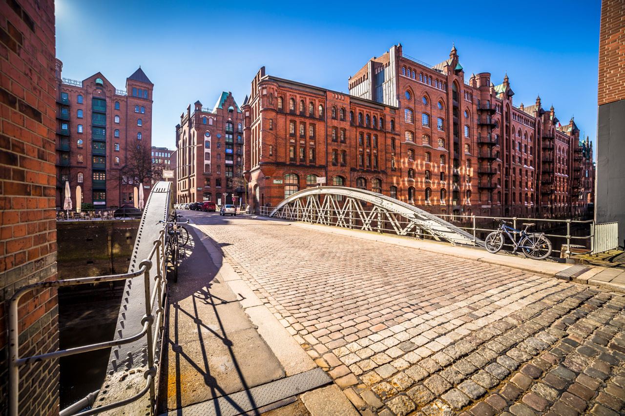 Kopfsteinpflaster-Brücke in der Speicherstadt mit Backsteinlagern und Fahrrädern