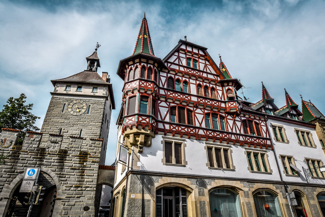 Stadttor mit Uhr und prachtvolles Fachwerkhaus mit Erkern und Ziegeldächern