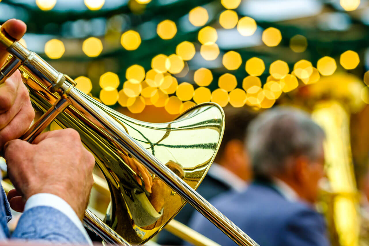 Detail einer Trompete bei Blasmusik, unscharfe Lichter im Hintergrund.