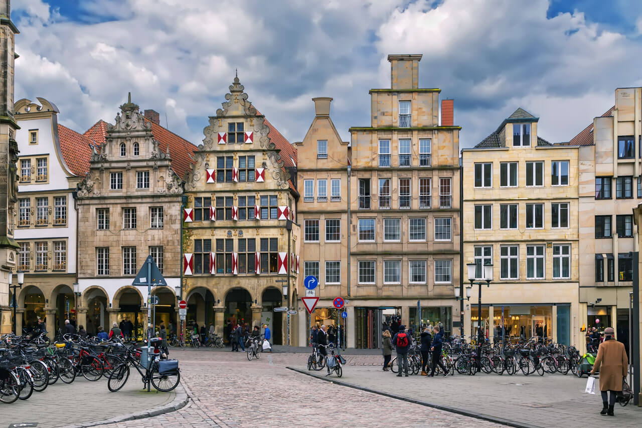 Giebelhäuser am Prinzipalmarkt mit vielen abgestellten Fahrrädern und Passanten.