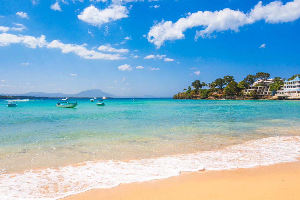 Strand mit türkisblauem Meer und Booten Sprachreise Dominikanische Republik Aussprache verbessern
