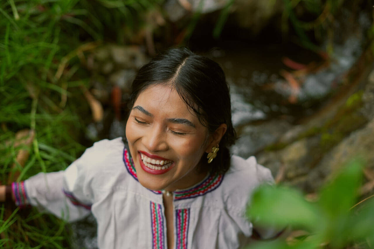 Indigene Frau lachend in der Natur Sprachreise Kultur erleben und Aussprache verbessern
