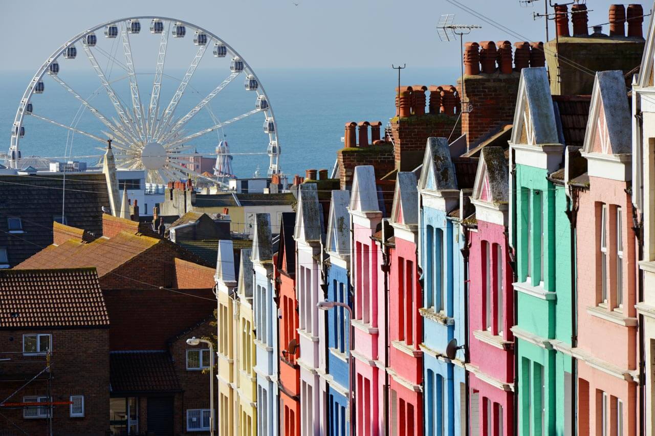 Bunte Häuserfassaden in Brighton mit Blick aufs Riesenrad Spaziergang zum Sprachkurs am Meer