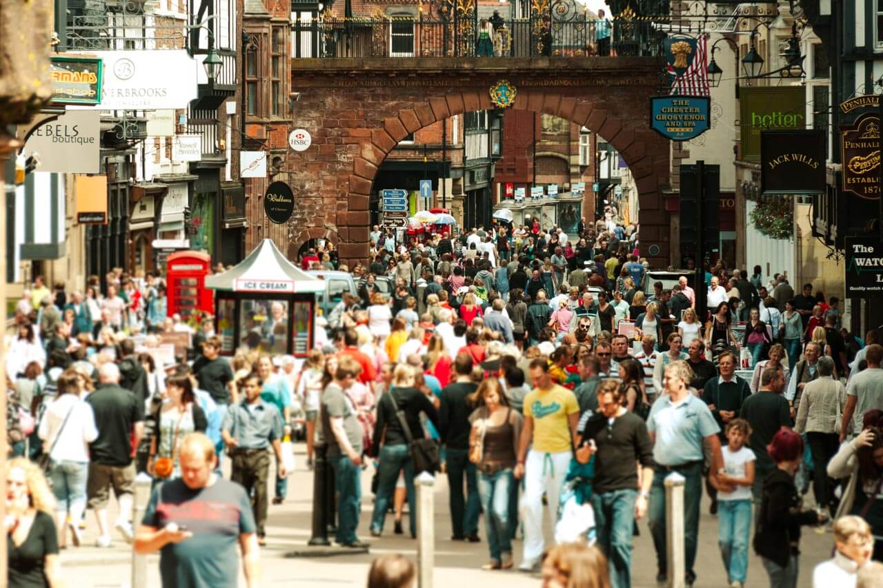 Belebte High Street in Chester unter historischem Tor Konversation üben im Alltag während der Sprachreise