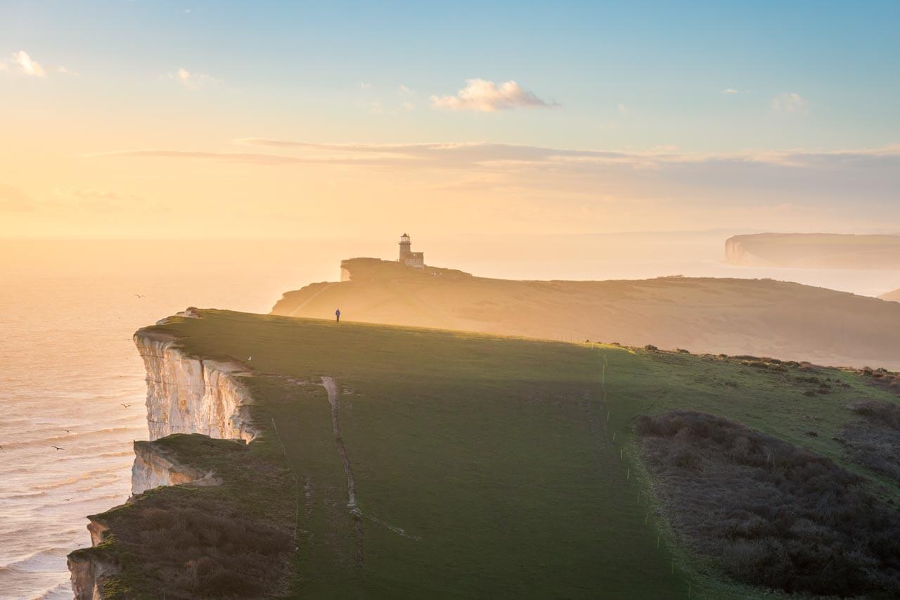 Seven Sisters bei Eastbourne mit Leuchtturm im Abendlicht Aussprache verbessern während der Sprachreise