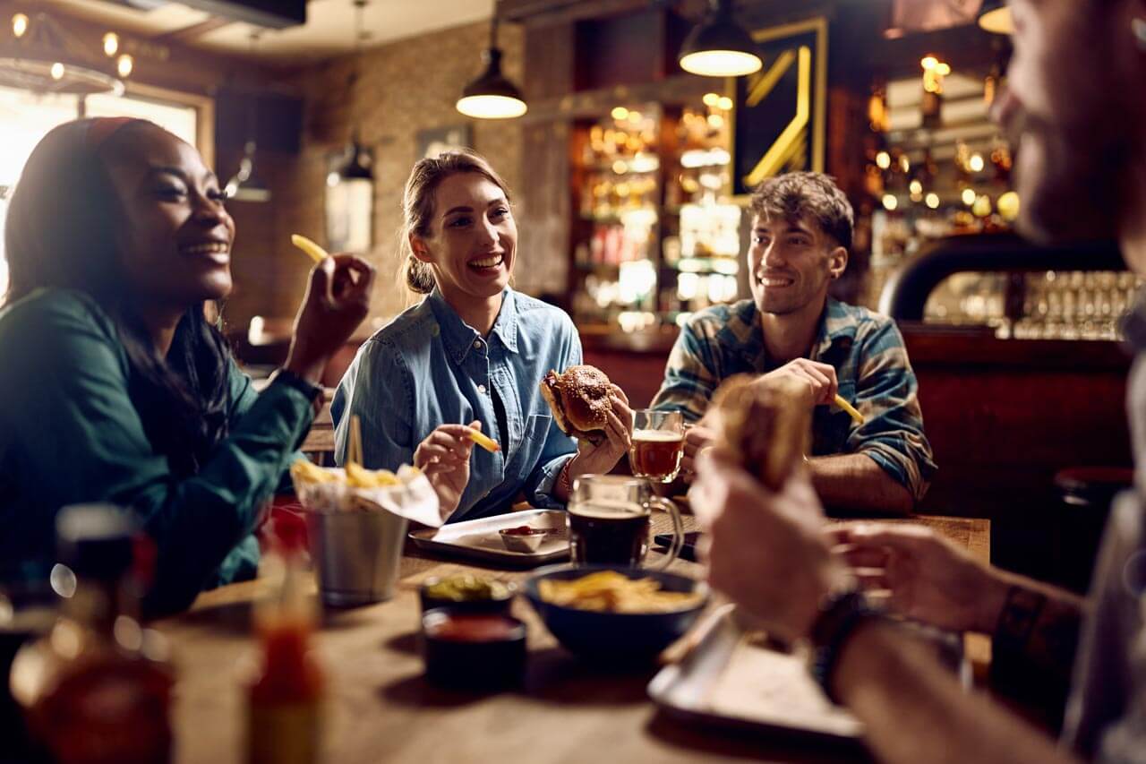 Freunde im Pub in Leeds beim Essen und Trinken Konversation und Small Talk trainieren während der Sprachreise