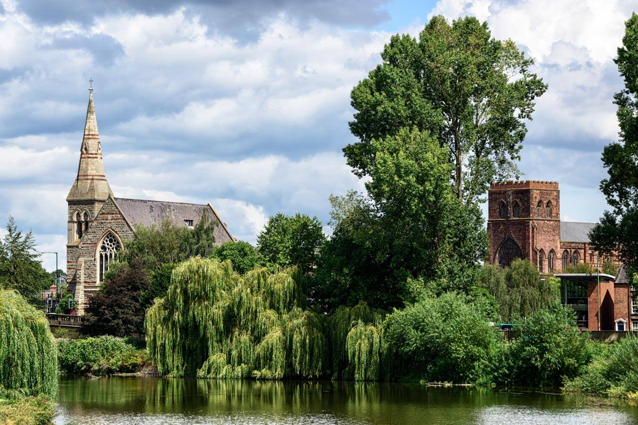 Gotische Abteikirche und reformationskirche am Fluss in Shrewsbury Hörverstehen üben in natürlicher Umgebung während der Sprachreise