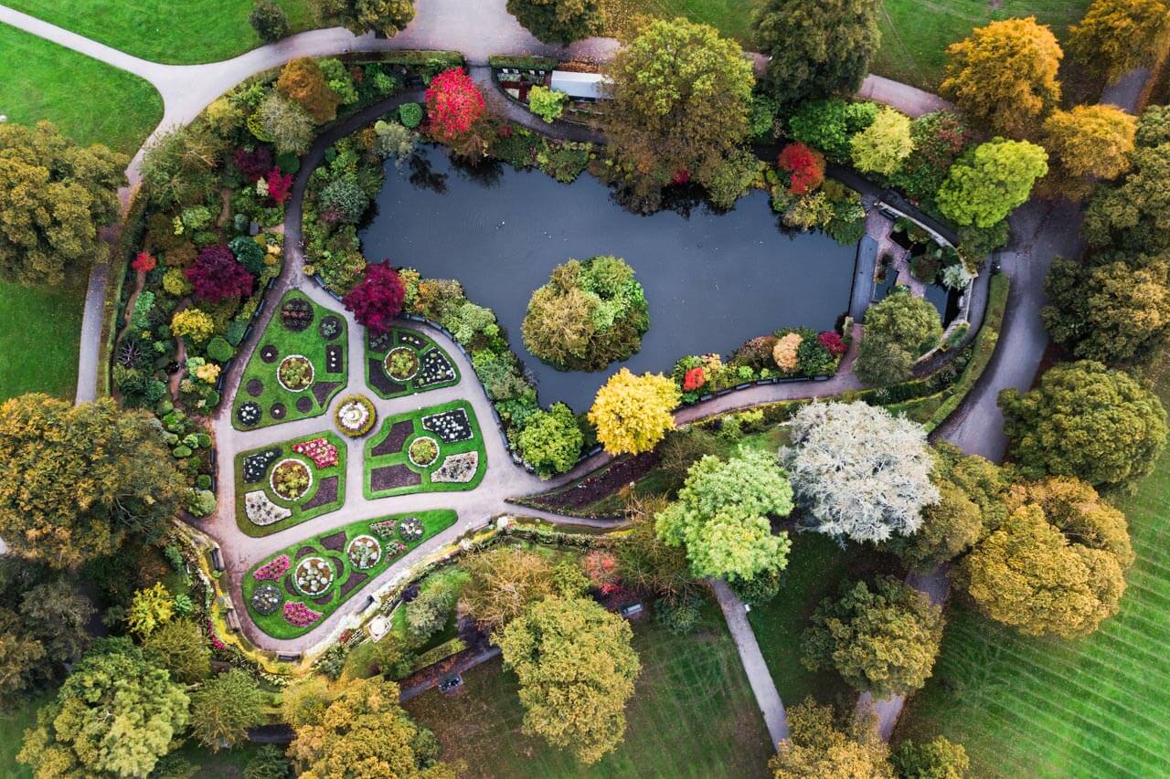 Quarry Park aus der Vogelperspektive mit formalen Beeten und See Schreiben trainieren mit Bildbeschreibung und Präpositionen