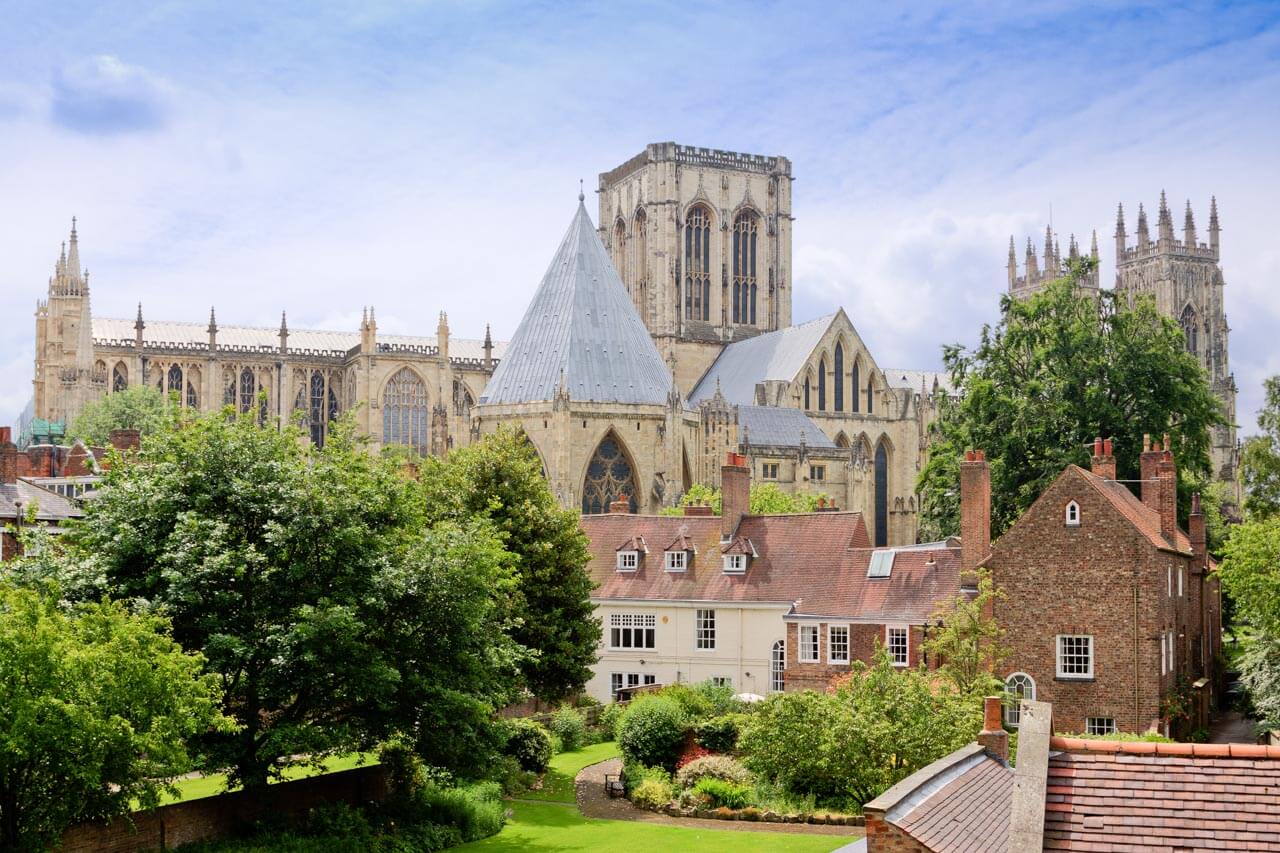 York Minster hinter Gärten und Backsteinhäusern Aussprache verbessern mit Architektur-Vokabular