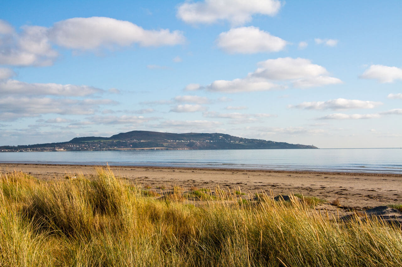 Dollymount Strand mit Dünen und Blick auf Howth Head Englisch lernen am Meer