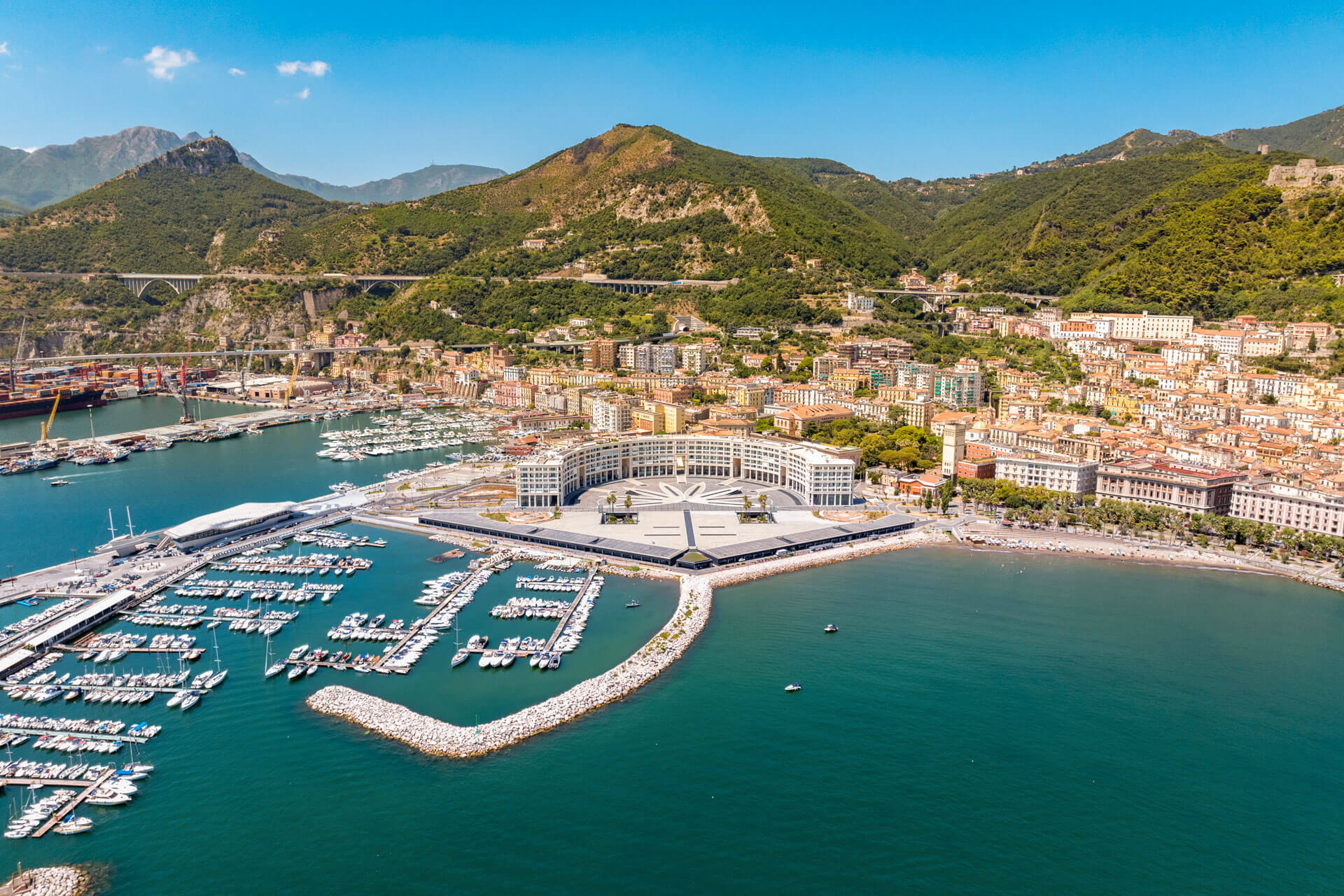 Luftaufnahme von Hafen und Stadt vor grünen Bergen Sprachreise erleben und Grammatik üben