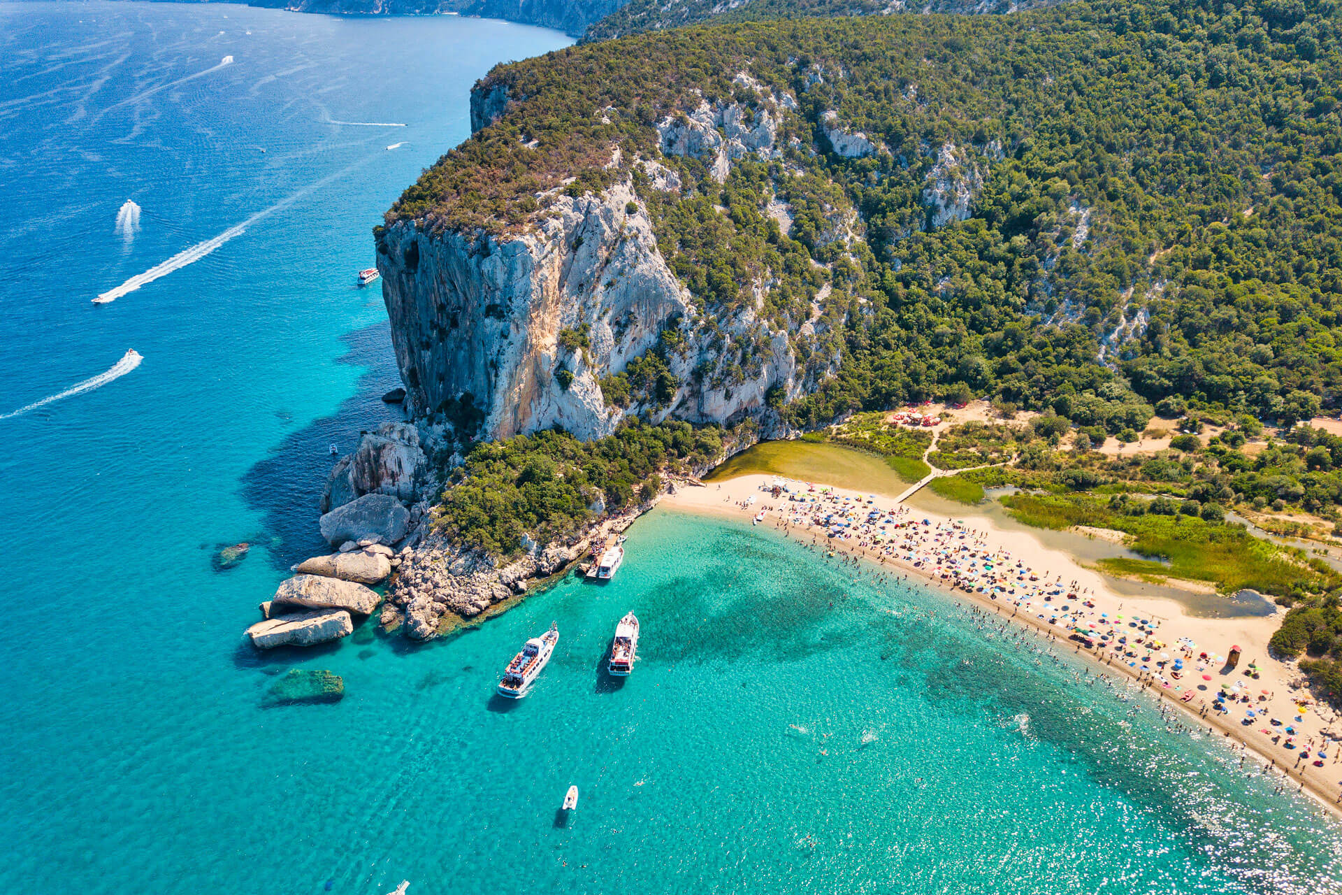 Luftaufnahme vom Cala Luna Strand mit Booten und Klippen Sprachreise erleben und Vokabeln üben