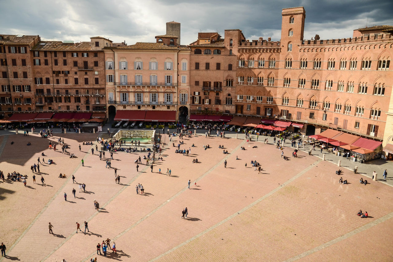 Piazza del Campo mit historischen Fassaden und Menschen Grammatik trainieren beim Sprachkurs