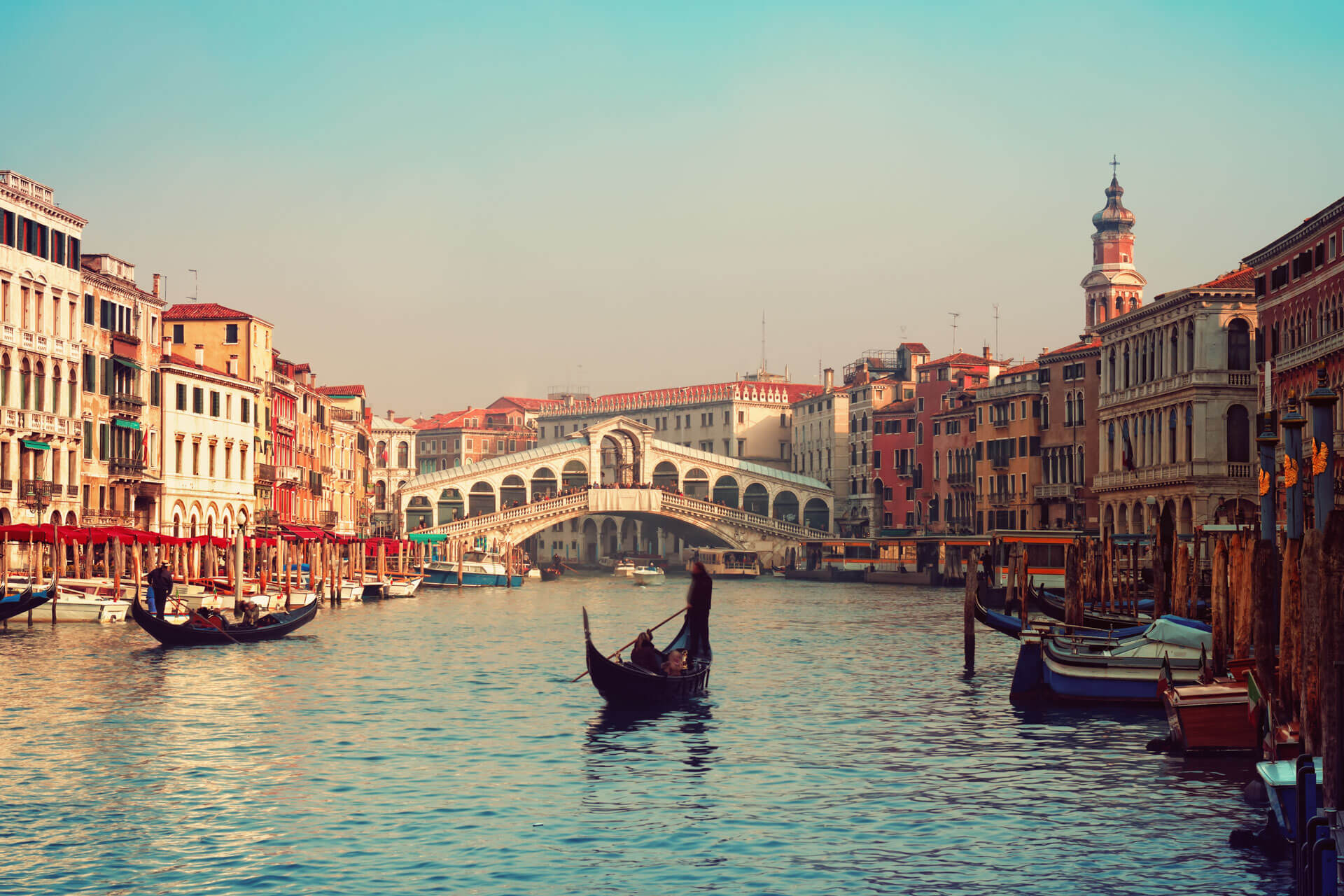 Gondeln auf dem Canal Grande mit Blick auf die Rialtobrücke – ideal für eine Sprachreise Italienisch in Venedig