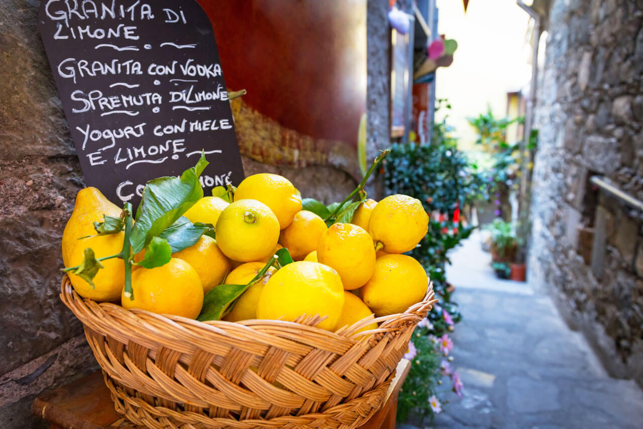 Korb voller Zitronen in Gasse von Corniglia Symbol für italienische Lebensart auf Sprachreise