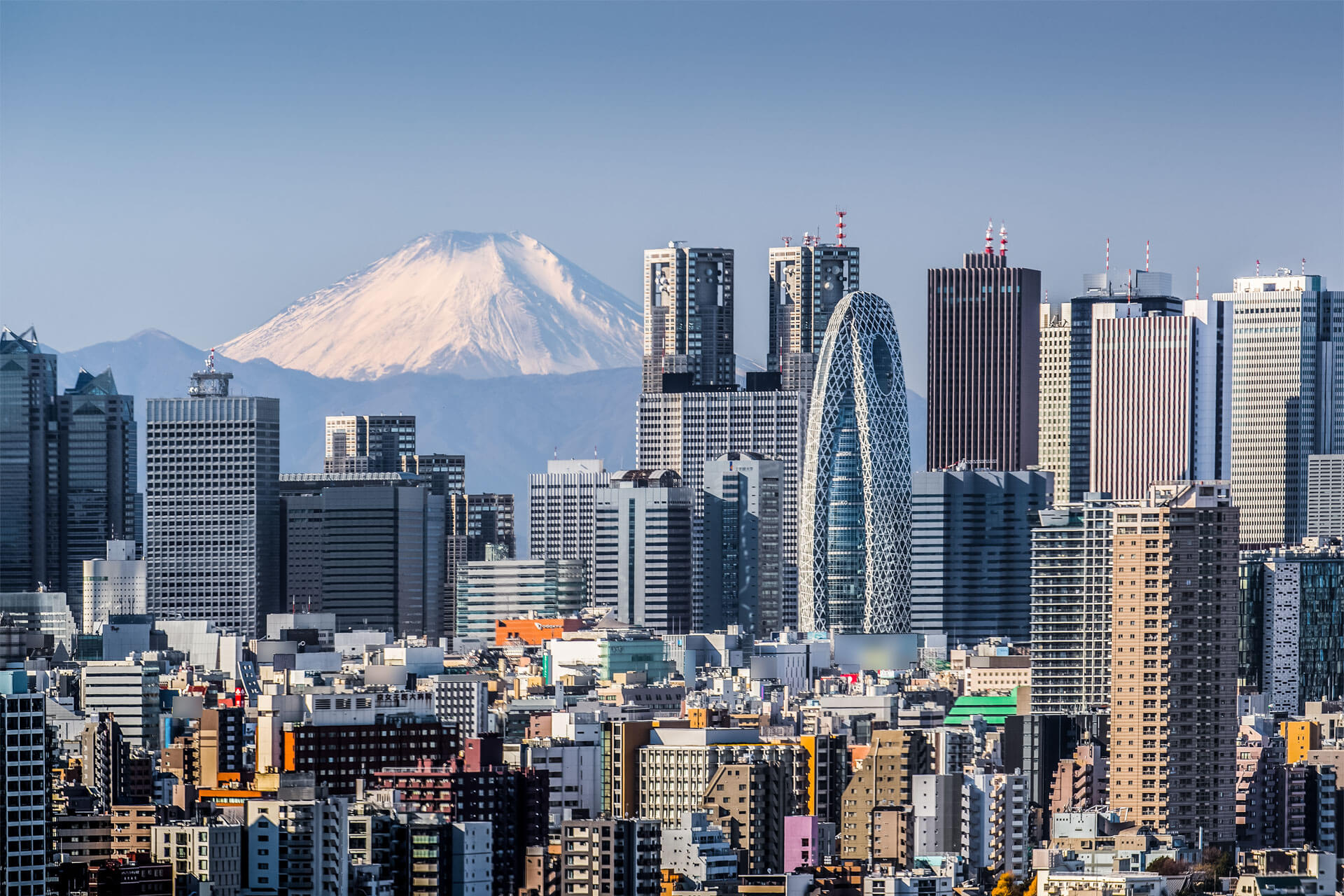 Tokio Skyline mit hohen Wolkenkratzern vor schneebedecktem Fuji bei klarem Himmel