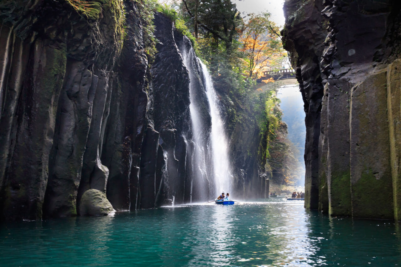 Bootsfahrt durch Takachiho-Schlucht mit Wasserfall Symbol für Naturerlebnis und Sprachreise Japan