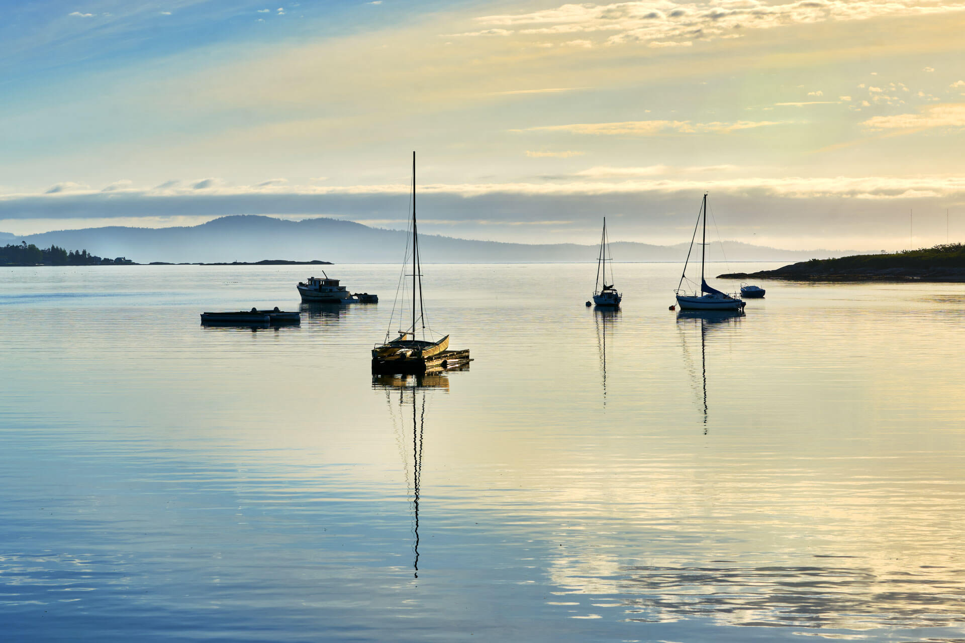 Segelboote auf ruhiger Bucht im Morgenlicht, Konversation und Hörverstehen üben auf Sprachreise