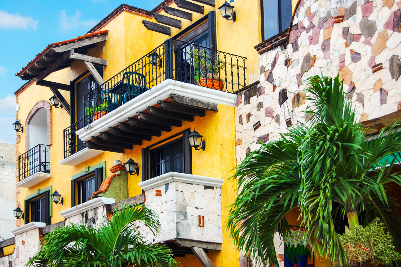 Bunte Fassaden mit Balkonen und Palmen Sprachreise Mexiko Schreibtraining im Alltag
