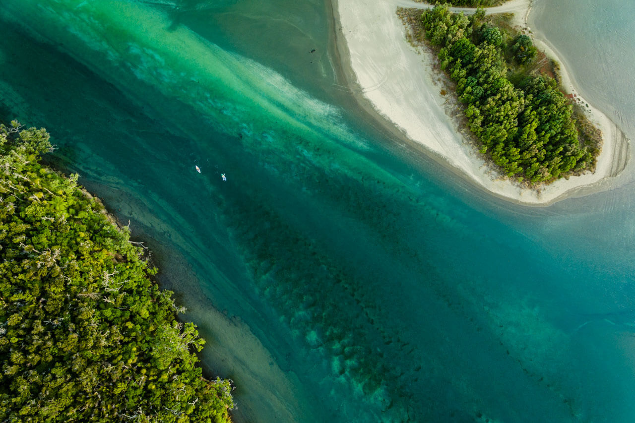 Drohnenblick auf türkisgrüne Lagune mit Sandbänken, Hörverstehen trainieren in Naturkulisse.