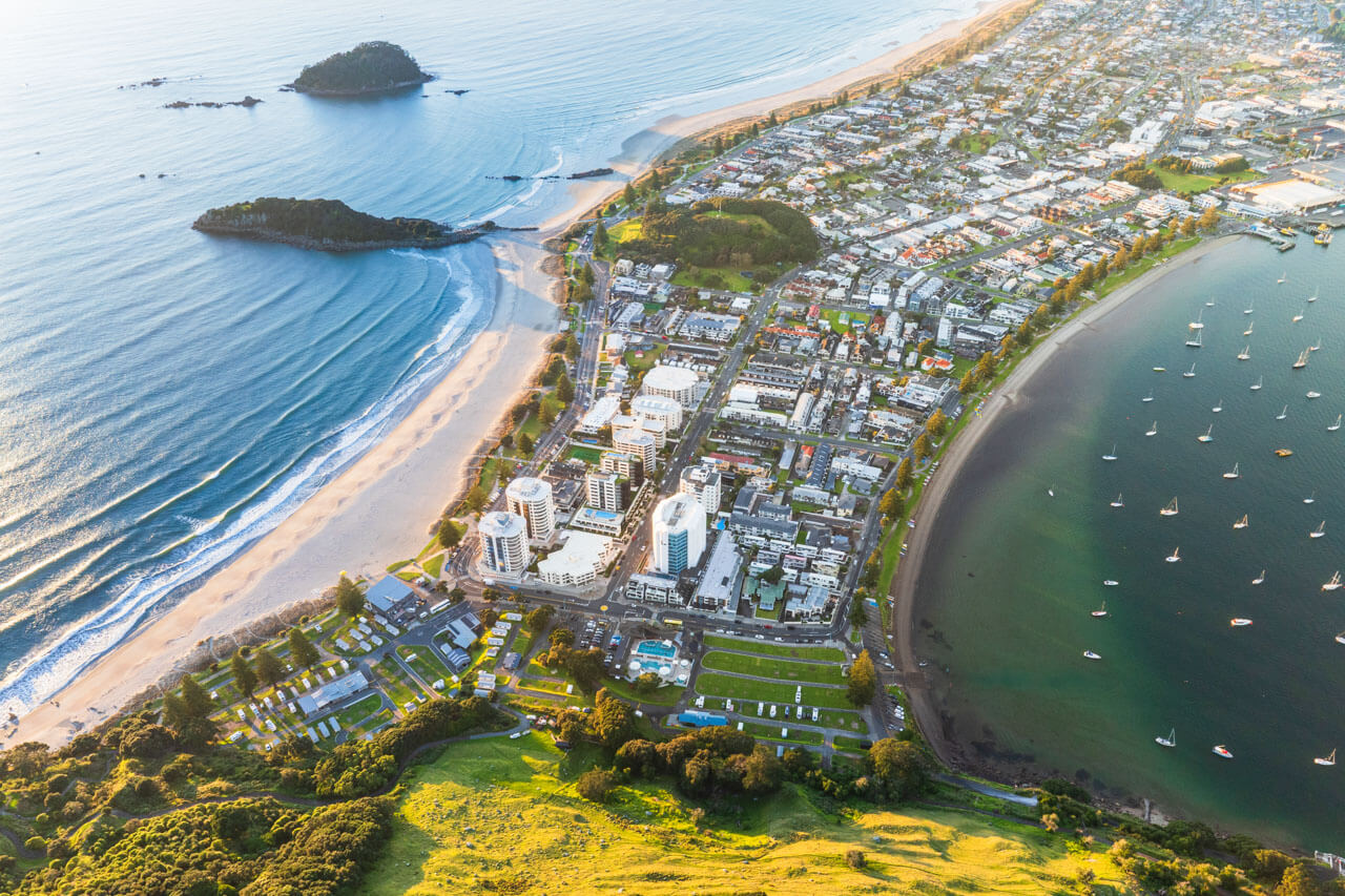 Luftbild von Mount Maunganui zwischen Ozean und Hafen, Sprachkurs in maritimer Umgebung.