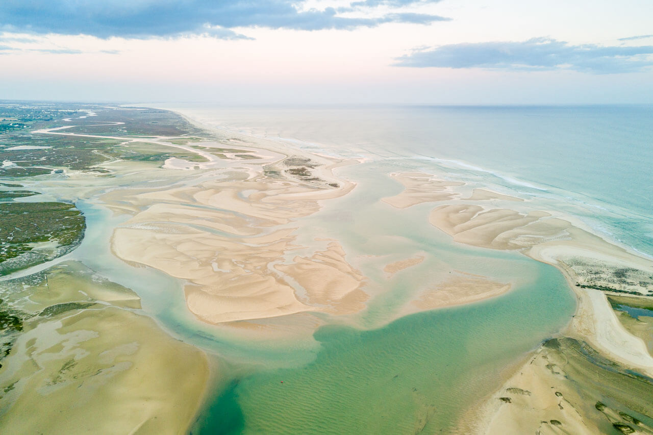 Drohnenaufnahme über die Ria Formosa mit Sandbänken und türkisblauem Wasser – Sprachkurs an der Algarve.
