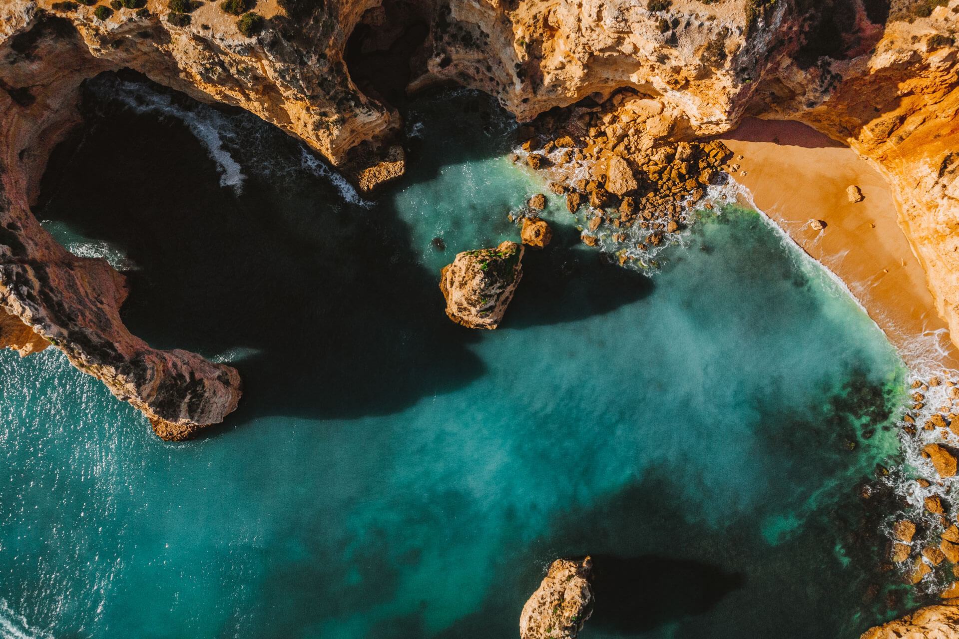 Luftaufnahme der Praia da Marinha an der Algarve mit türkisblauem Wasser und Felsformationen.