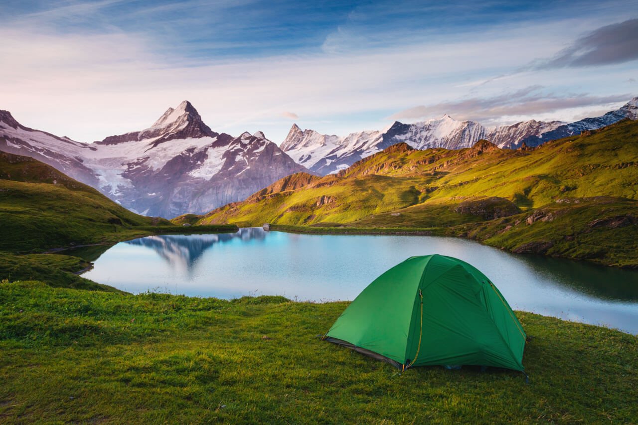 Zelt am Bergsee bei Abendlicht, Grammatik trainieren nach dem Sprachkurs in ruhiger Natur