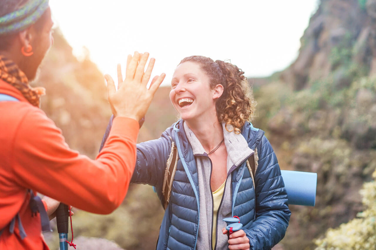 Wanderteam gibt sich High Five, Motivation auf der Sprachreise, Konversation üben unterwegs